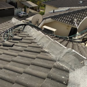 גג רעפים עם צלחות לוויין וכבלים חשמליים