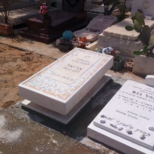 שני מצבות עם כיתוב בעברית ועיטורים צבעוניים