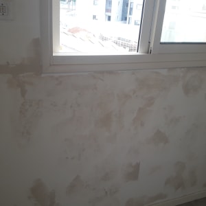 קיר עם תיקוני טיח ליד חלון