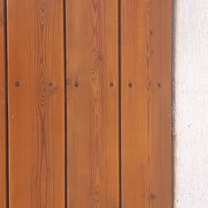 לוחות עץ חומים עם טקסטורה על קיר בטון