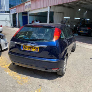 מכונית כחולה בחניה ליד מוסך