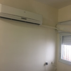 קיר צבוע בגוון בהיר עם מזגן מותקן