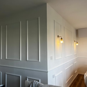 קיר גבס עם פנלים דקורטיביים ותאורה צמודת קיר