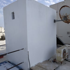 קיר צבוע בלבן עם כתמי צבע על הרצפה