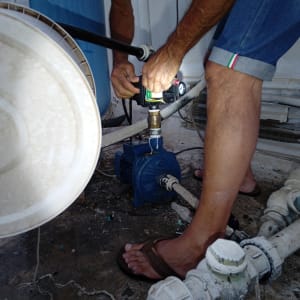 אדם מתקן משאבת מים עם כלי עבודה