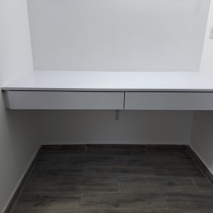 שולחן עבודה לבן עם מגירות מותקן על קיר