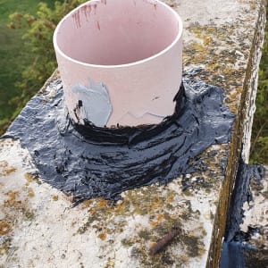 צינור אטום בחומר שחור על משטח בטון