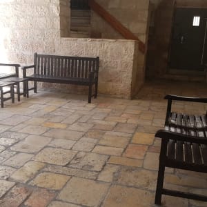 ספסלי עץ במסדרון אבן עם רצפת אבן