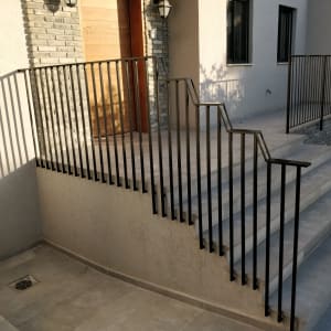 מעקה מתכת שחור על מדרגות חיצוניות