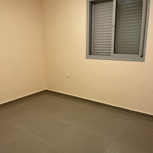 חדר עם קירות גבס ורצפת אריחים אפורים