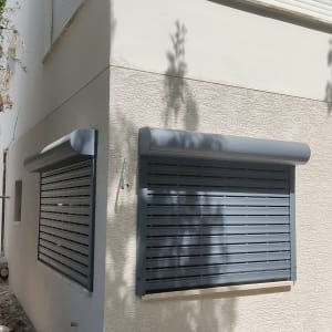 תריסי אלומיניום אפורים על קיר חיצוני