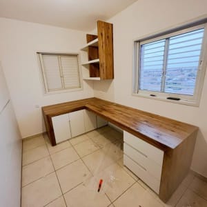 שולחן עבודה מעץ עם מדפים ומגירות בחדר עבודה