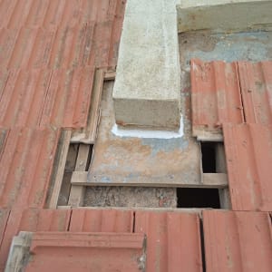 רעפים אדומים עם חלקים חסרים על גג