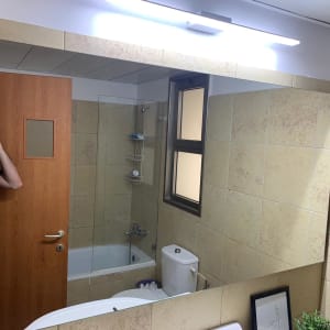 מראה גדולה בחדר אמבטיה עם חלון זכוכית