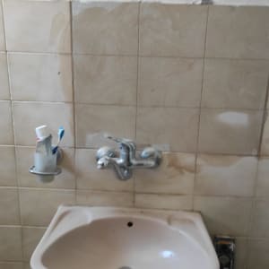 תיקון אריחי קרמיקה וטיוח קיר מעל כיור בחדר רחצה