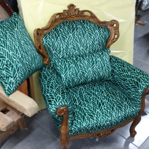 כורסה מרופדת בבד ירוק עם דוגמת עלים