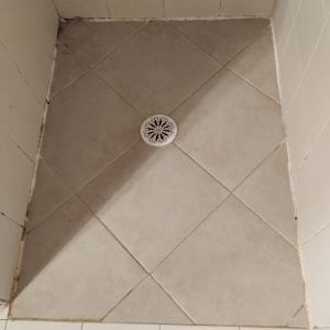 רצפת מקלחת עם אריחים וניקוז במרכז