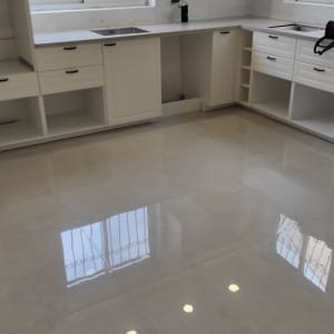 רצפה מבריקה במטבח עם ארונות לבנים