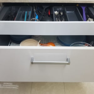 מגירות מטבח פתוחות עם כלי מטבח וצלחות