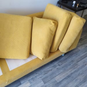 כריות ספה צהובות מונחות על ספה לניקוי