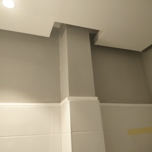 קיר צבוע בגוון אפור עם תקרה לבנה