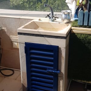 ארון עם דלת כחולה מתחת לכיור חיצוני