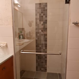 מקלחון עם דלת זכוכית וריצוף אפור