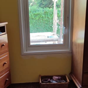 חלון אלומיניום עם מסגרת לבנה על קיר צהוב