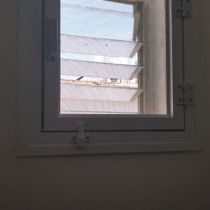 חלון אלומיניום עם תריסים פתוחים ורשת