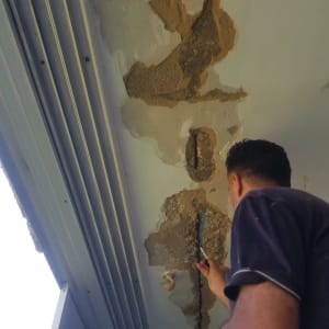 אדם מתקן קיר עם שפכטל וחומר איטום