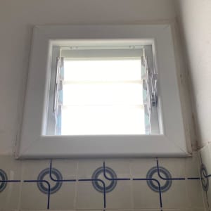 חלון עם תריסי אלומיניום פתוחים למחצה