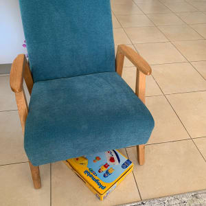 כיסא כחול עם ידיות עץ על רצפה מרוצפת