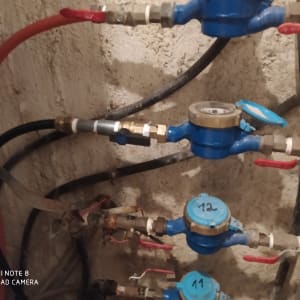 מד מים כחול עם ברזים אדומים וצינורות