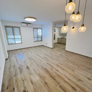 רצפת עץ חדשה ותאורה מודרנית בחלל משופץ