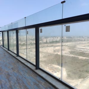 מעקה זכוכית מלוכלך במרפסת עם סימני לכלוך