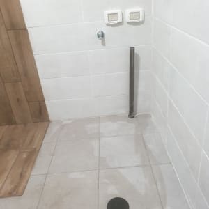 קיר עם אריחים, שקעי חשמל וצינור חשוף