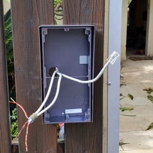 קופסת חיבורים עם כבלים חשופים על גדר עץ