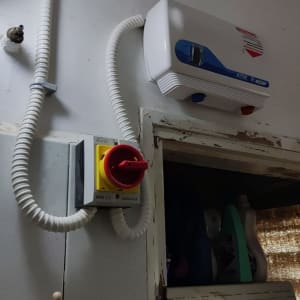 מתג חשמלי עם כבל גמיש ומכשיר חשמלי על הקיר