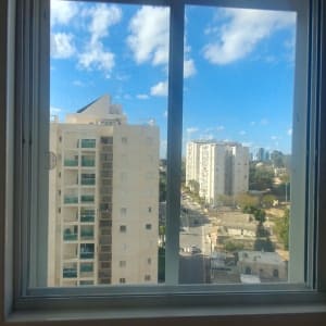 חלון אלומיניום עם נוף עירוני ברקע