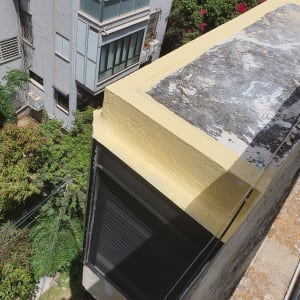 גג צבוע בצהוב עם קיר חיצוני של בניין