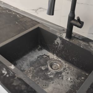 כיור מלוכלך עם כתמי סבון ומים על השיש