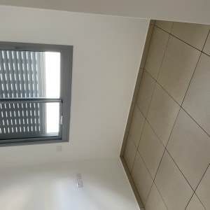 רצפה נקייה עם אריחים בהירים וחלון עם תריסים