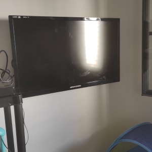 טלוויזיה תלויה על הקיר עם כבלים מחוברים