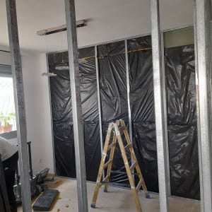 קירות גבס בבנייה עם מסגרת מתכת וסולם עץ