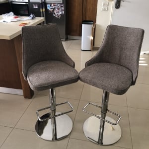 שני כיסאות בר מרופדים עם רגלי מתכת מבריקות