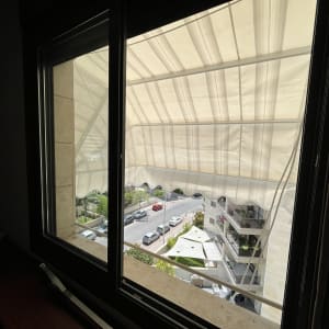 סוכך בד לבן מחוץ לחלון עם קפלים