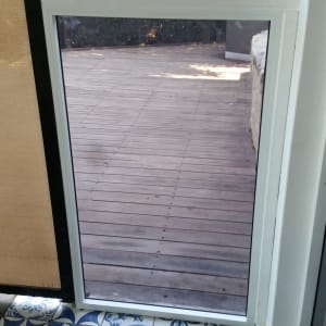 חלון זכוכית עם נוף לחצר עץ