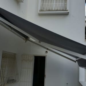 סוכך אפור מותקן על קיר חיצוני של בניין.