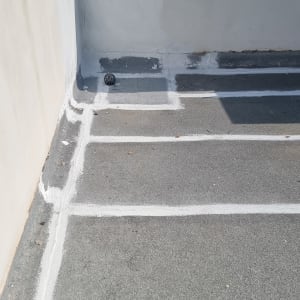 קווים לבנים של איטום על גג בטון אפור