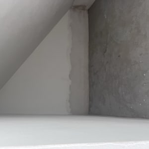 קיר צבוע חלקית עם סימני צבע אפור ולבן